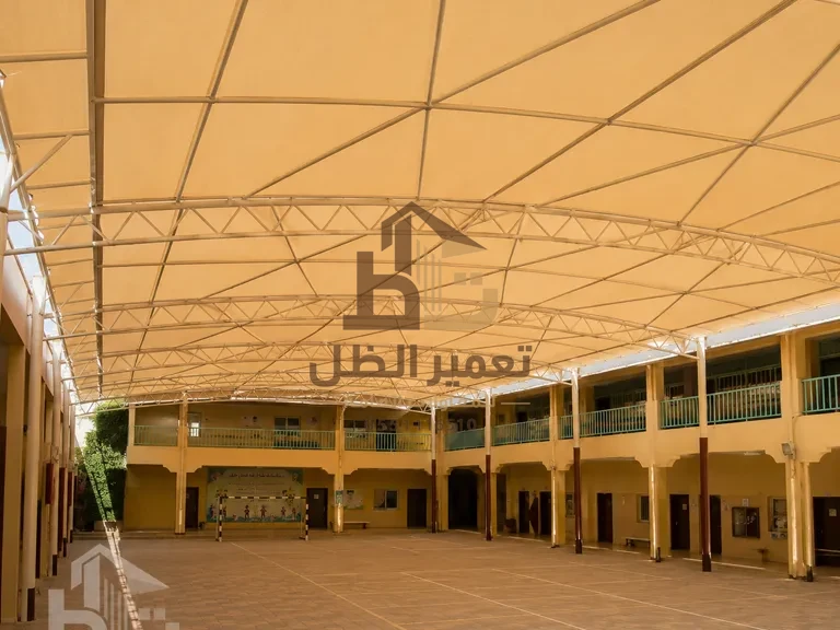 مظلة مدرسية واسعة توفّر ظلًا لطلاب أثناء الطابور الصباحي