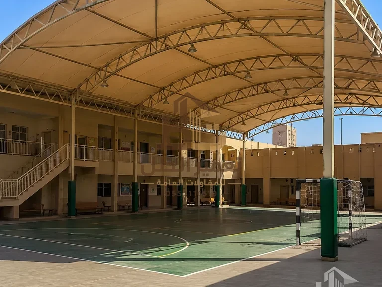 مظلة مقوّسة واسعة فوق ملعب مدرسي (تصور توضيحي)