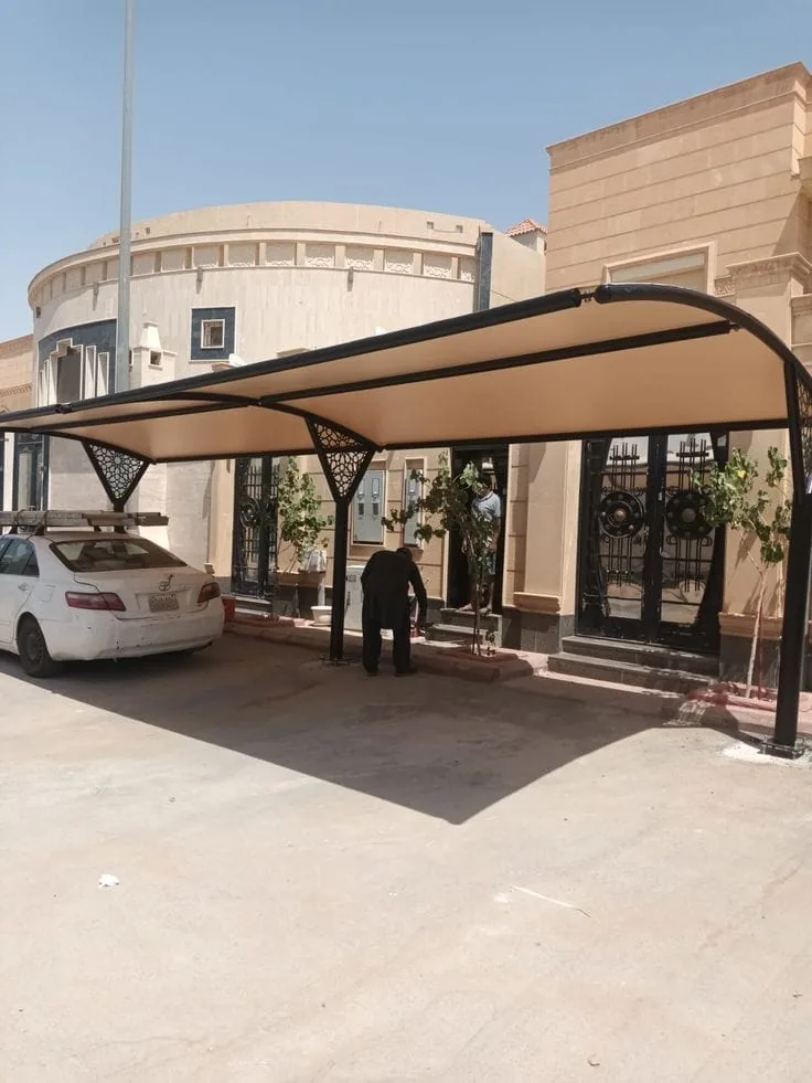 مظلة مواقف سيارات بأذرع معدنية مزخرفة بالقصّ بالليزر أمام مدخل منزل