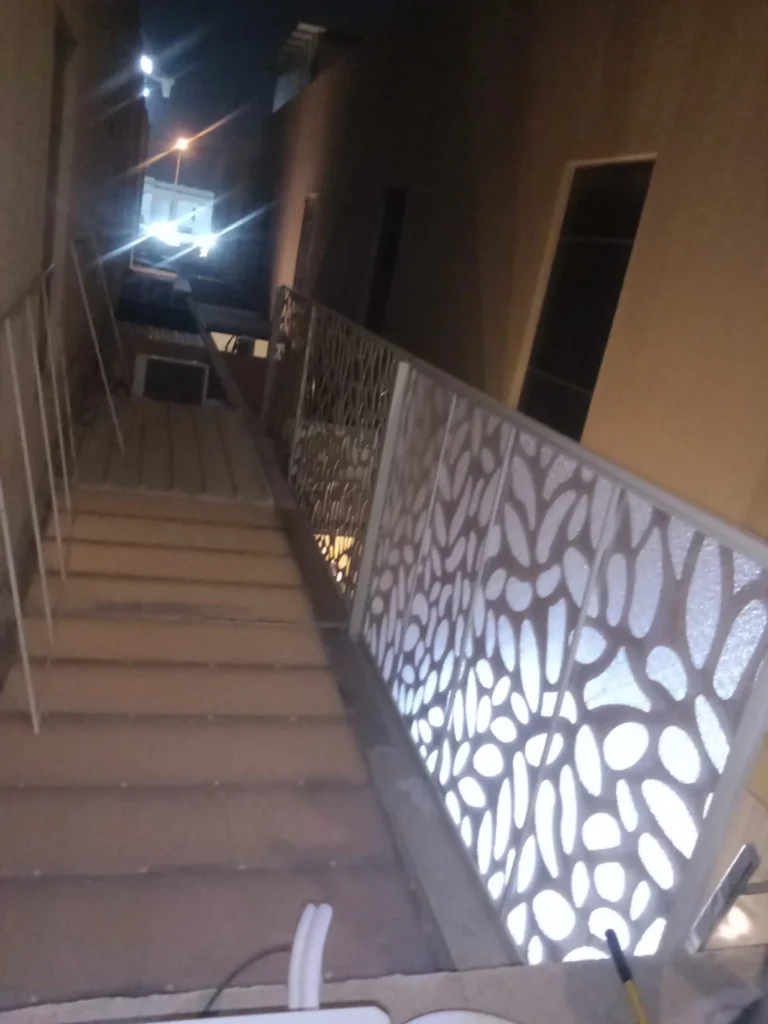 سواتر ليزر بيضاء على جانب درج خارجي مضاءة ليلاً