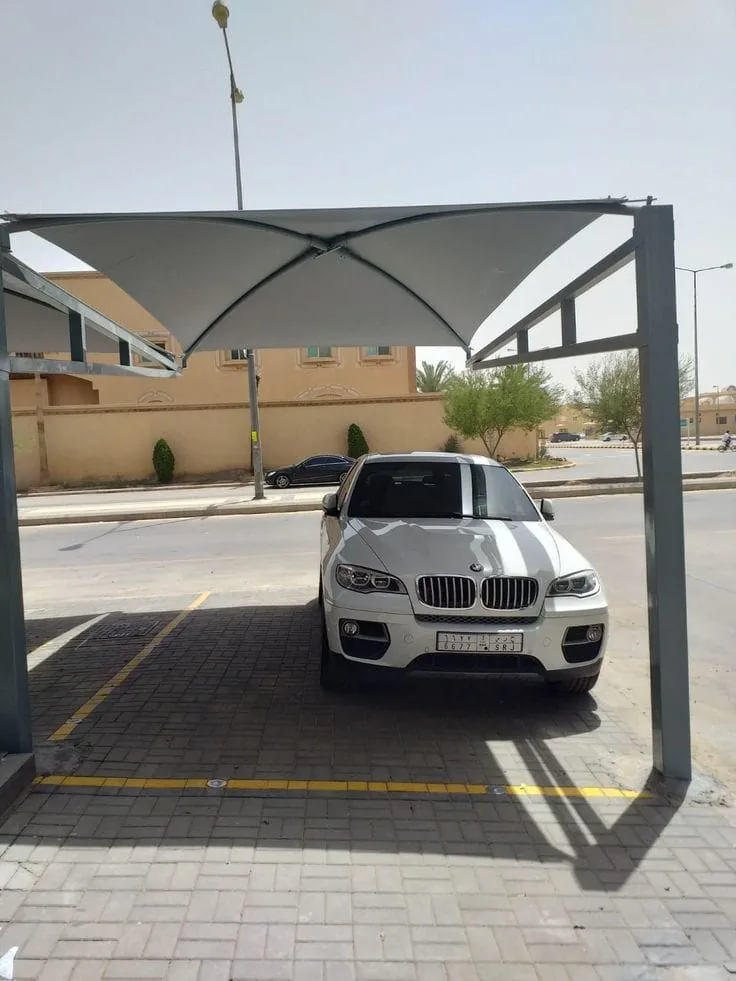 مظلة موقف سيارات بهيكل حديد مربّع الشكل وغطاء قماشي