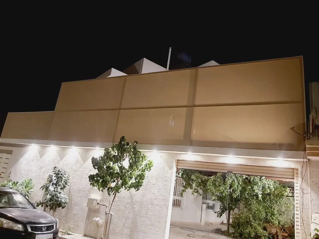 ساتر ألواح صمّاء بلون بيج أعلى سطح منزل ليلاً