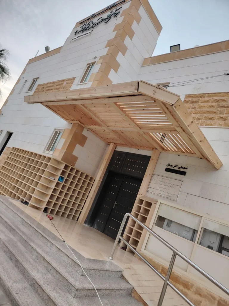 مظلة مدخل بمظهر خشبي بشرائح متباعدة فوق باب مصلى