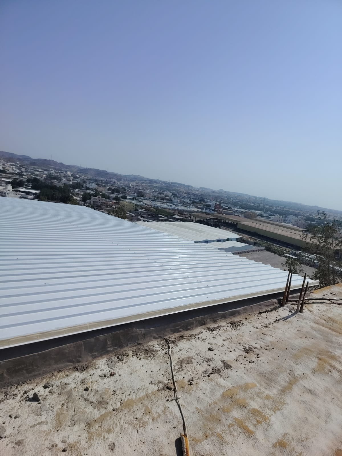 سطح أبيض من ألواح الساندوتش بانل تظهر سماكة اللوح عند حافته